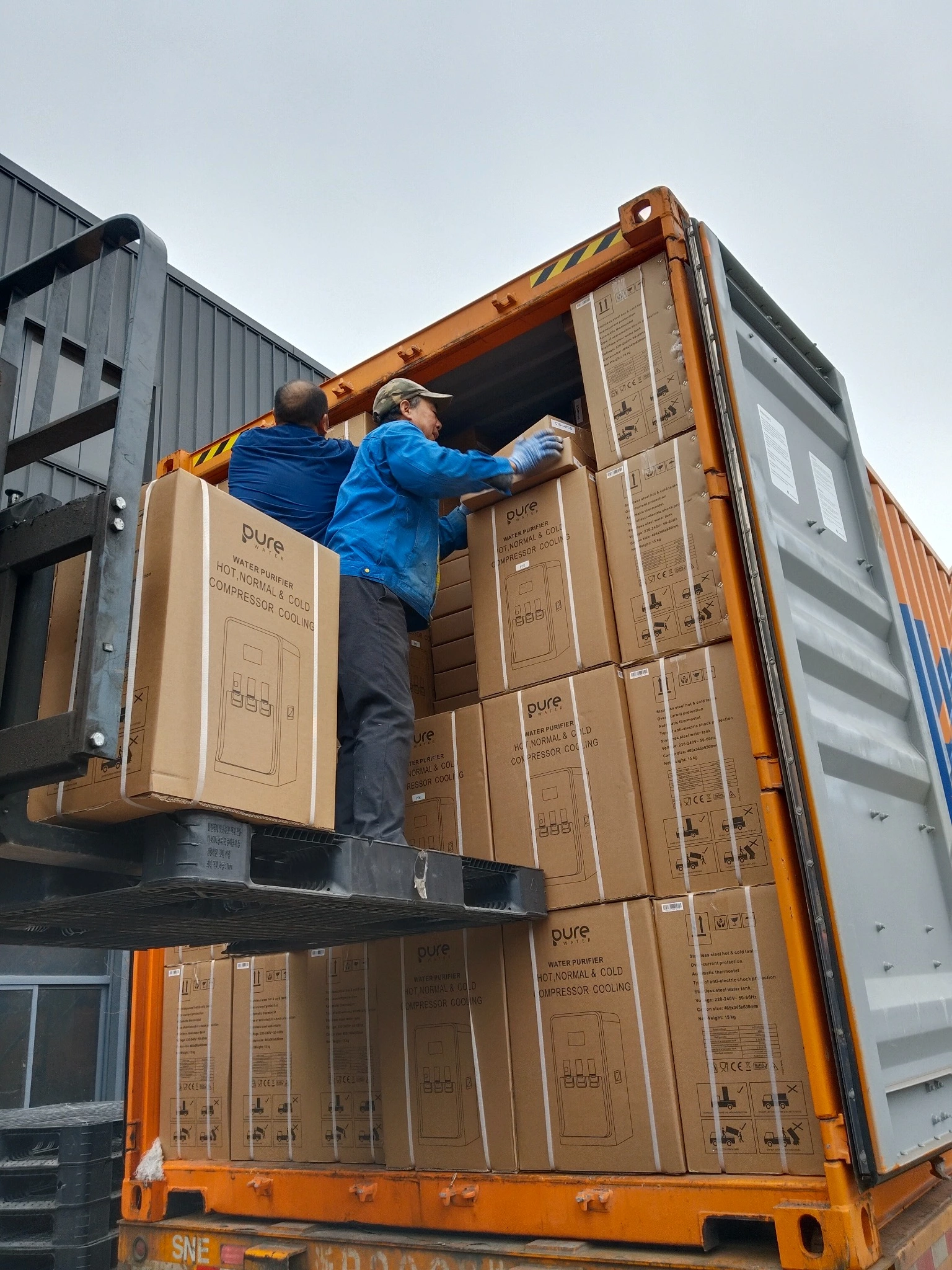 Loading Pure Water water dispenser cartons into an export container